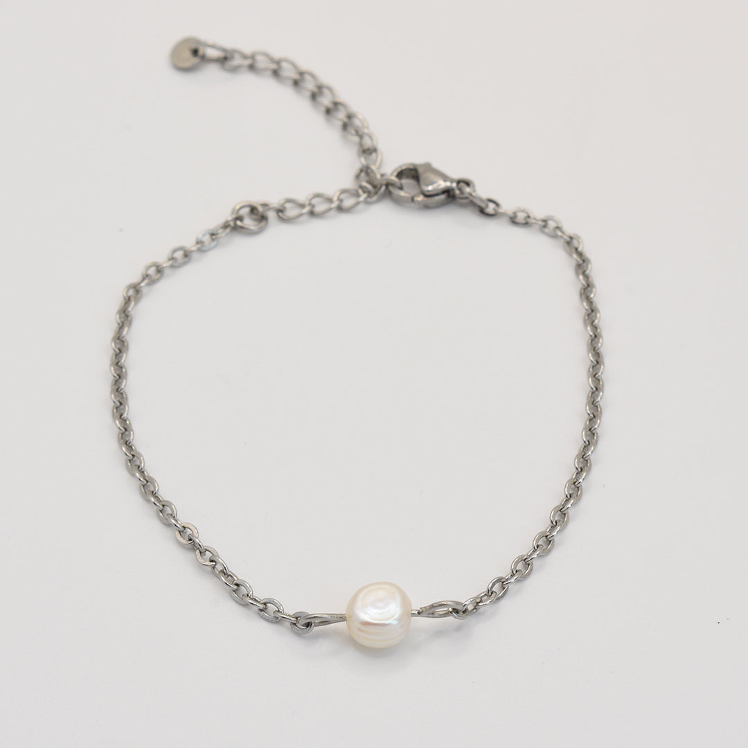 Salty Dreamers Armband Cutie Pearly Silber: Handgefertigte silberne Edelstahlkette mit einzelner weißer Süßwasserperle auf weißem Hintergrund.