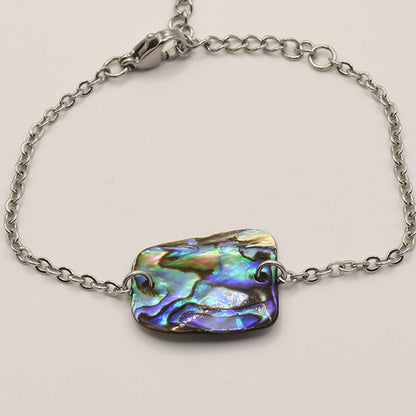 The Bracelet | Paua Shell Marama by Salty Dreamers is a handmade silver chain bracelet with a rectangular, iridescent pāua shell centerpiece showcasing swirling blue, green, and purple tones—a beautiful piece of New Zealand jewelry.