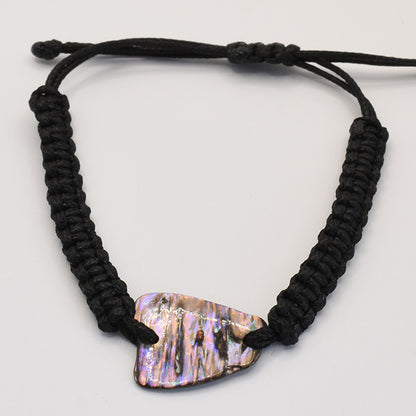 The Salty Dreamers Bracelet | Paua Shell Toa is a black, handmade macrame-style bracelet with a polished, iridescent New Zealand abalone shell centerpiece, displayed on a plain white background.