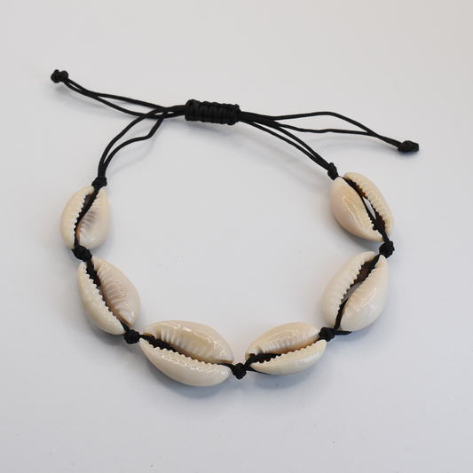 The Salty Dreamers Bracelet | Cowrie Away Black features six white cowrie shells on black cord with an adjustable knot, handmade and displayed on a plain white background.