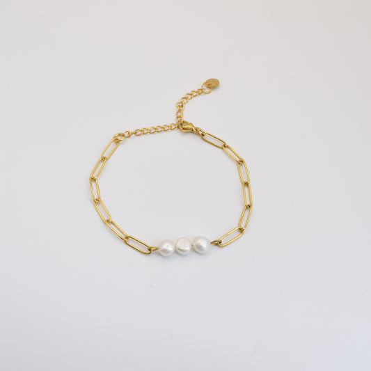 The Salty Dreamers Bracelet | Paperclip Pearly Gold features a gold stainless steel paperclip chain, three freshwater pearls at the center, and an adjustable clasp, shown on a plain white background.