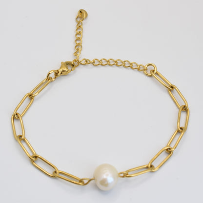 The Bracelet | Paperclip Cutie Gold by Salty Dreamers is a handmade gold chain with elongated links and a central freshwater pearl, featuring an adjustable clasp and shown on a white background.