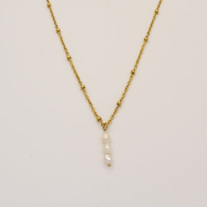 The Necklace | Cutie Pearlies by Salty Dreamers features a delicate gold chain with small bead accents and a handmade pendant of four vertically stacked white pearls, shown against a plain white background.