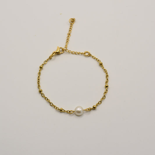 The Bracelet | Cutie Pearly Gold by Salty Dreamers features a delicate gold chain with small beads and a central white pearl, handmade for minimalist surfer style. Shown against a plain white background.