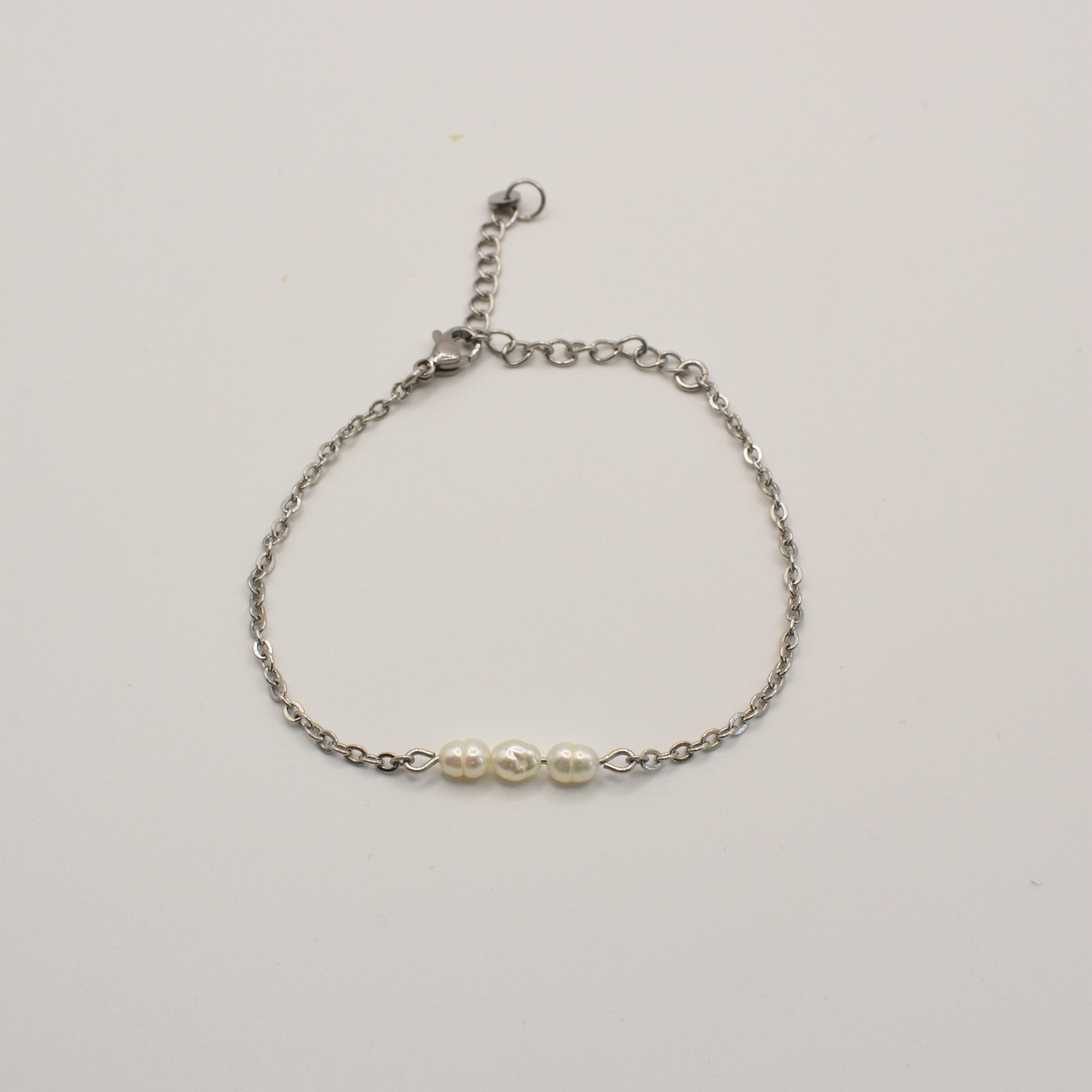 The Pretty Pearly Silver Bracelet by Salty Dreamers features a delicate silver chain and three small white pearls at the center, shown against a plain white background.