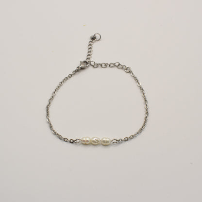 The Pretty Pearly Silver Bracelet by Salty Dreamers features a delicate silver chain and three small white pearls at the center, shown against a plain white background.