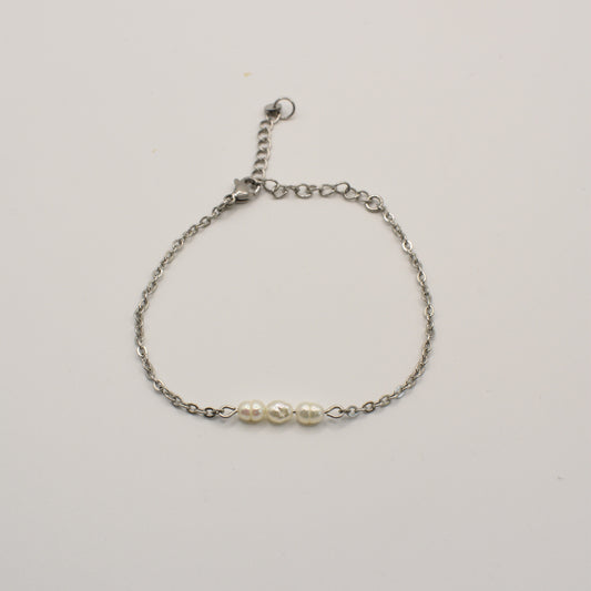 The Pretty Pearly Silver Bracelet by Salty Dreamers features a delicate silver chain and three small white pearls at the center, shown against a plain white background.