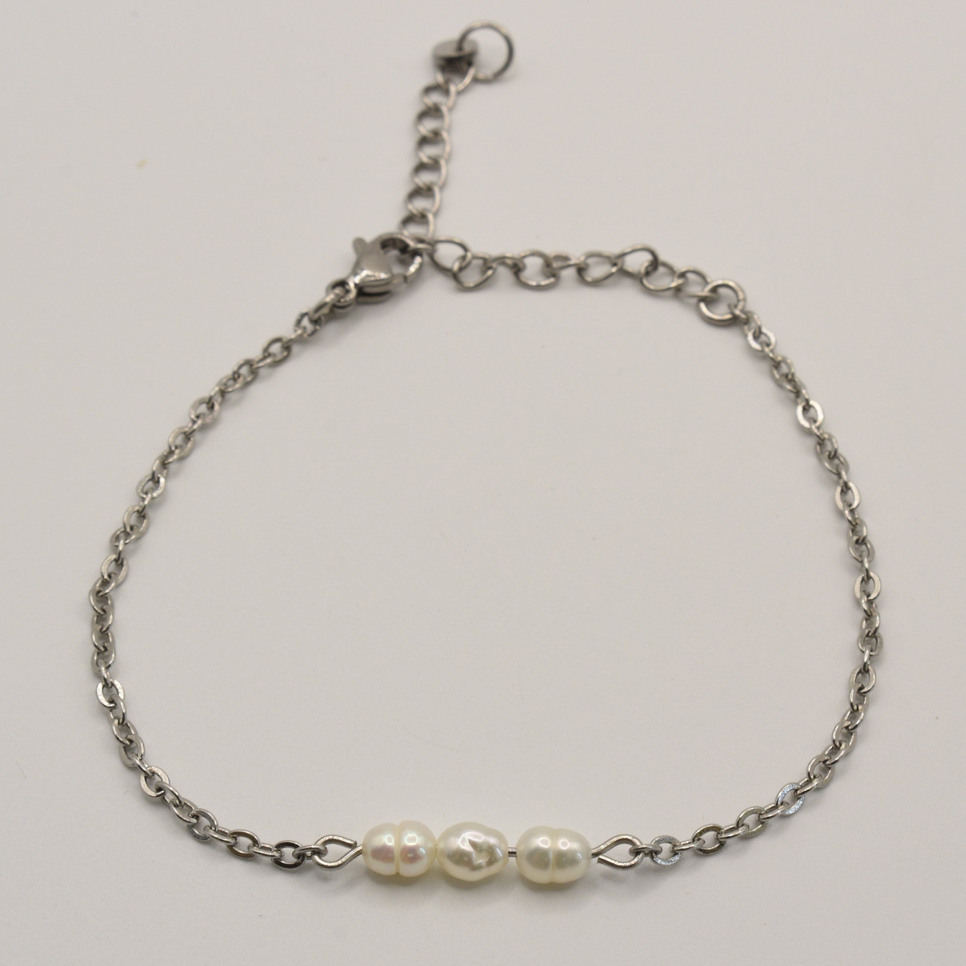 The Pretty Pearly Silver bracelet by Salty Dreamers is a delicate handmade piece with three white freshwater pearls on a silver chain and an adjustable clasp, shown on a plain white background.