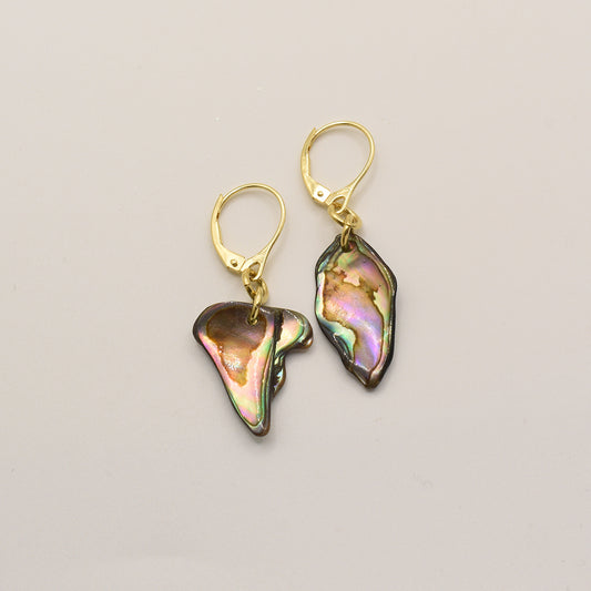 The Salty Dreamers Earrings | Paua Shell Ngakau are handmade gold leverbacks, each with an irregular iridescent New Zealand abalone pendant in green, pink, and purple tones, displayed on a neutral background.