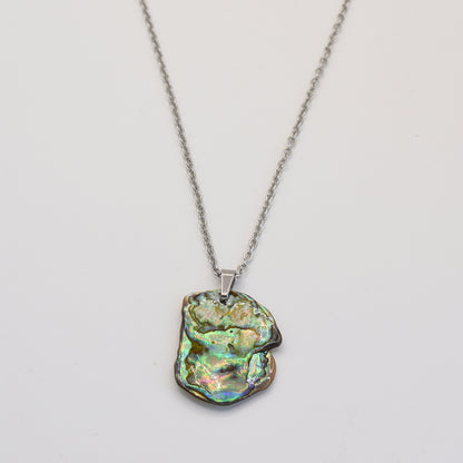 The Necklace | Paua Shell Kaukau by Salty Dreamers features an iridescent, irregular pāua shell pendant on a silver chain—a handmade piece that showcases natural beauty, displayed on a plain white background.