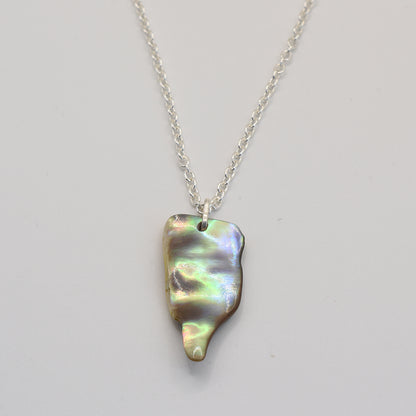 The Salty Dreamers Necklace | Paua Shell Ruru features a handmade sterling silver chain with an irregular, iridescent abalone shell pendant, perfect for ocean jewelry lovers. Shown on a plain white background.