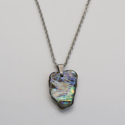 The Salty Dreamers Necklace | Paua Shell Pae is a handmade silver chain with an iridescent pāua shell pendant in blue, green, and purple tones—a stunning piece of New Zealand jewelry shown on a plain white background.