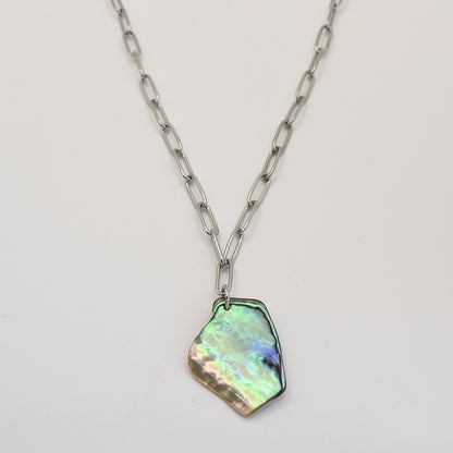 The Salty Dreamers Necklace | Paua Shell Koura features a chunky silver stainless steel link chain with an iridescent, irregular-shaped pāua shell pendant, shown against a plain white background.