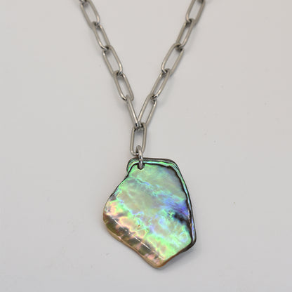 The Salty Dreamers Necklace | Paua Shell Koura showcases a large, iridescent pāua shell pendant on a silver chain, displayed against a plain white background.