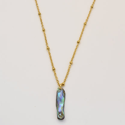 Salty Dreamers Paua Shell Ra Necklace—a gold chain with small beads and a vertical iridescent paua shell pendant, handmade and inspired by New Zealand jewelry, shown on a plain white background.