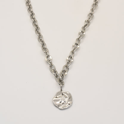 The Necklace | Ocean Dollar Silver by Salty Dreamers features large, round silver links and a textured sand dollar pendant, crafted from stainless steel and showcased against a plain white background.