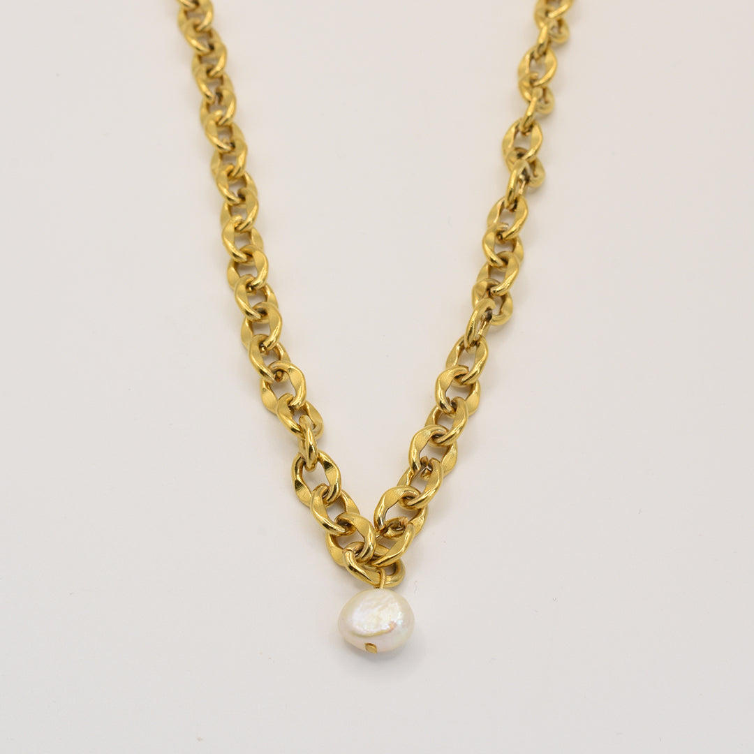 The Pearl Necklace by Salty Dreamers features medium gold links and a central round white pearl pendant, capturing handmade elegance and showcased on a simple white background.