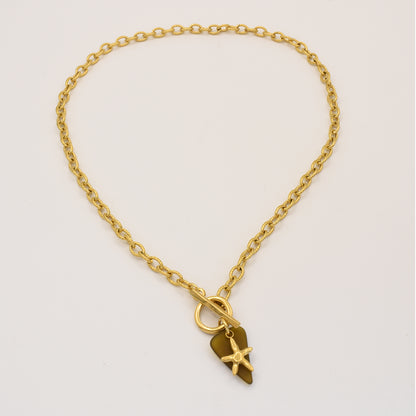 The Salty Dreamers Necklace | Star Sea Glass features a golden stainless steel chain with an irregular gold pendant, adorned with a small star detail, shown on a plain white background.