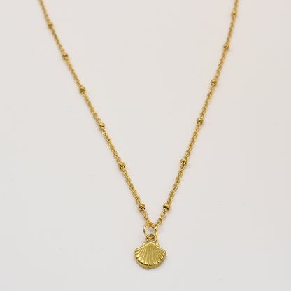 The Necklace | Little Sunshine by Salty Dreamers features a delicate gold chain with bead accents and a small gold seashell pendant, displayed on a plain white background—a perfect piece of handmade jewelry.