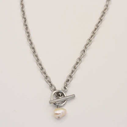 The Cutie Pearl necklace by Salty Dreamers is a modern handmade silver chain with a central toggle clasp, featuring a single irregular freshwater pearl charm.