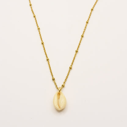 The Necklace | Simplified Cowrie Gold by Salty Dreamers is a handmade gold chain necklace with subtle bead accents and a single cream cowrie pendant, inspired by classic puka shell designs, shown on a plain white background.