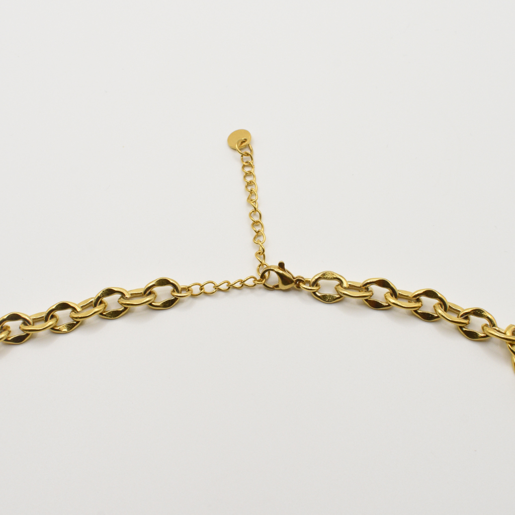 A close-up of the Salty Dreamers Necklace | Paua Shell Tautahi—a gold chain with clasp and extender, showcasing a beautiful abalone pendant—displayed on a white background.