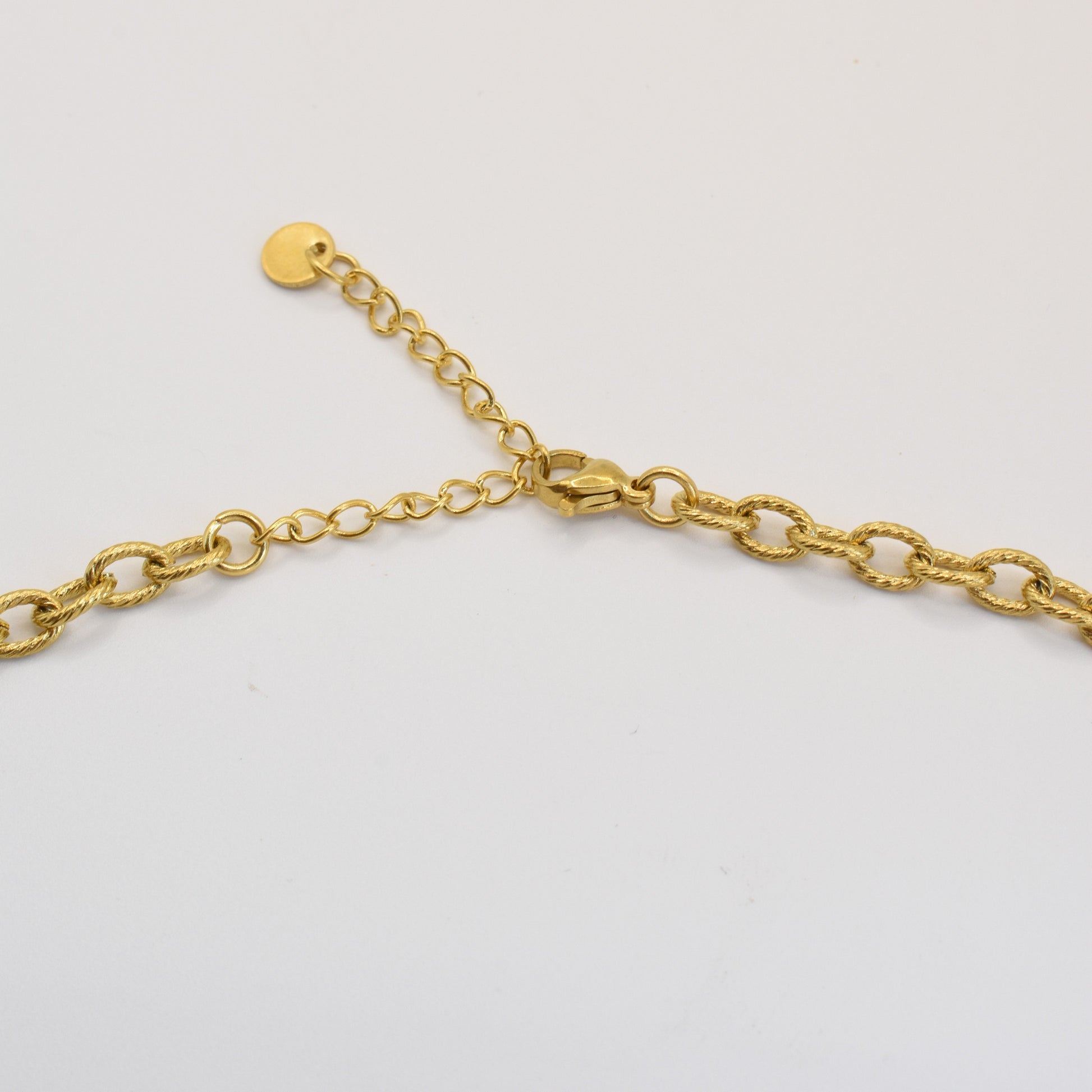 A close-up of the Salty Dreamers Necklace | Turtle Sea Glass, a gold chain with an adjustable extender and lobster clasp, featuring a golden sea glass detail, displayed on a plain white background.